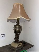 Full view of the vintage table lamp showing brass base, stone accent and scalloped lampshade.