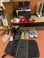Full lot view with boots, shoes, RedSkins hats, toiletry bag, and car organizer on bench and floor.