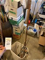 Photo showing several copper and metal pipes grouped together inside a white container.