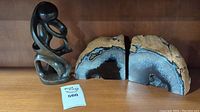Two abstract soapstone carving and agate gemstone bookends on wooden shelf