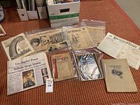 Photo of various antique and vintage newspapers, magazines, and books laid out on surface