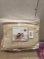Clear plastic packaged beige Best Season full bed sheet set with product label showing family image and 'Money Back Guarantee'.