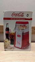 Boxed Coca Cola hot air popcorn maker showing product and branding on the front.
