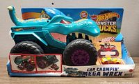 Front view of Hot Wheels Monster Trucks Car Chompin' Mega Wrex with included Hot Wheels car in package