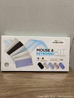 Front view of Mouse & Keyboard Kit box showing images of keyboard in five color options including white and mentioning uninterrupted working time of 150h.