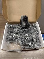 10 pack of Neupo 48V power adapters packed in a box, each adapter wrapped in plastic with cables visible