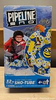 Front packaging of Pipeline Sno High Motion Sno-Tube showing a child riding the snow tube on snow, with design and size details