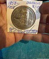 Front side of Canadian Silver Dollar coin with totem pole design, dated 1858-1958, marked as British Columbia silver dollar.