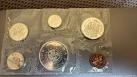 Front view of uncirculated Canadian coin set sealed in Royal Mint packaging showing all seven coins including the 1964 CharlotteTown Quebec dollar.