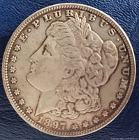 Obverse of 1897 Morgan Silver Dollar coin showing Liberty head and date.