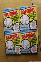 Four factory sealed 1989 Fleer Baseball wax packs laid flat on a wooden surface, showing front of packaging.