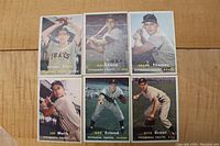 Six vintage 1957 Topps Pittsburgh Pirates baseball cards laid out on a wooden surface featuring Johnny Kline, Dale Long, Frank Thomas, Lee Walls, Bob Friend, Dick Groat.