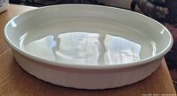 Image showing the interior and side details of the round quiche dish with fluted edges and glossy white finish.