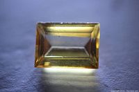 Top-down macro image of the rectangular yellow sapphire showing its baguette cut and internal clarity.