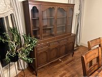 Front and side views of the wooden china cabinet showing glass doors, wood finishes, drawers, and cabinet doors.
