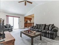 Image showing a living room set with a striped fabric sofa and armchair, and a wooden cocktail table with glass top in front, next to a brick fireplace.