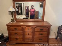 Full view of the large wooden dresser with attached rectangular mirror, showing the overall condition and style.