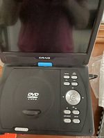 Front view of the black Craig portable DVD player showing the open screen and control buttons on the base unit.