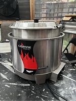 Front view of stainless steel rethermalizer with inset well and hinged lid, ‘Cayenne’ flame logo visible