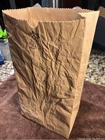 Front view of the ceramic vase showing crumpled paper bag design and scalloped rim