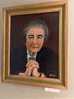 Front view of the framed portrait painting showing Golda Meir with hands clasped, signed by S Plener in the bottom right corner.