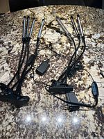Two grow lights laid out on a granite countertop showing flexible arms, clamps, power plugs, and USB connections.