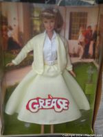 Front view of Barbie doll dressed as Sandy from Grease in original box, showing outfit and logo clearly.