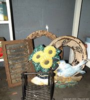 Photo showing cast iron and metal wall vents, cast iron stove pipe grate, two decorative cast iron door stoppers (bird and boot with sunflowers), rusty metal horseshoe