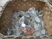 Basket holding various glass and crystal bottle stoppers in assorted sizes and shapes