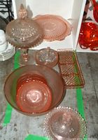 Lot photo showing all pink glassware including platter, compote, pickle dish, butter dish, sugar bowl, and bowls on floor