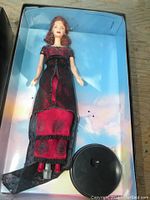 Close-up photo of Titanic Rose Barbie doll in original box, showing doll in detailed black and red gown with stand.
