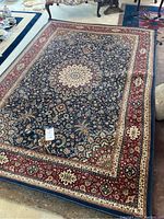 Full view of Ariana rug, showing central medallion and floral design with red border.