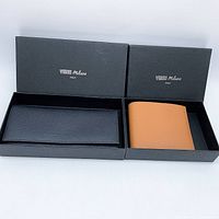 Two Italian leather bi-fold wallets, one black and one brown, displayed in their black Verri Milano Italy branded boxes.