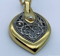Close-up image showing the front of gold-plated pendant with genuine pearl on filigree design.