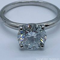 Close-up top view of the cushion cut moissanite solitaire ring on a polished 925 sterling silver band.