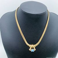 Front view of gold-plated necklace with rhinestone pendant featuring blue stone.