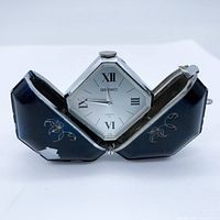 Front view of vintage Seiko Momotaro pocket watch opened with hexagonal face and black decorated case.