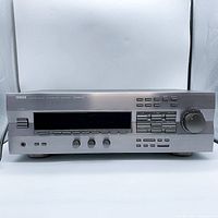 Front view of Yamaha DSP-R493 AV amplifier showing controls, display, and power switch.