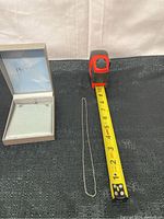 Sterling silver necklace next to a measuring tape, showing length around 22 inches.