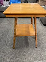 Front view of the parlour table showing the top surface, spindle legs, and lower shelf.