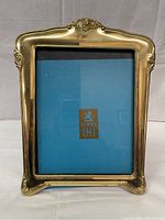 Front view of a gold-tone decorative Birks picture frame with embossed floral detailing and curved edges. Frame size 9.5 by 13 inches.