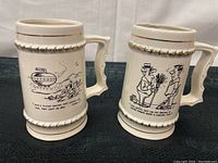 Side view of two ceramic mugs showing black and white curling-themed cartoons with humorous captions and gold trim accents.