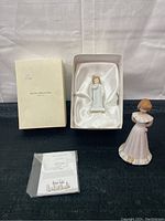Overview of two Royal Doulton figurines, boxed Darling figurine in white gown and a girl figurine in pink dress, plus certificate of authenticity and original box.