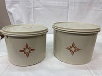 Two vintage almond-colored Tupperware containers with brown starburst design, side-by-side with lids on.