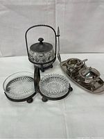 Overview photo showing vintage glass and metal tableware items arranged on a white cloth background.