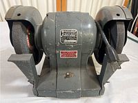 Front view of Black & Decker bench grinder showing dual grinding wheels and metal body.