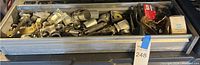 Wide view of tray containing assorted metal plumbing and electrical parts such as fittings, bolts, screws, and clamps.