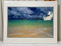 Photo of signed photographic print with white matting showing Hawaiian beach scene with islands and cloudy sky.