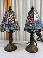 Pair of Tiffany style floral stained glass night lamps with brass-tone bases shown from front and side.