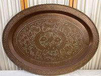 Full view of the oval brass tray showing the overall shape, size, and engraved designs.